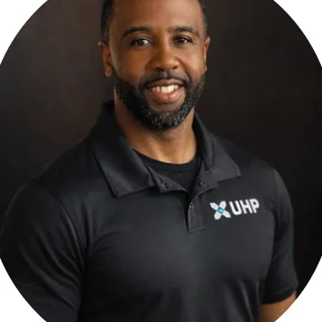 Coach Brandon Sowers smiling in a black Synergy polo